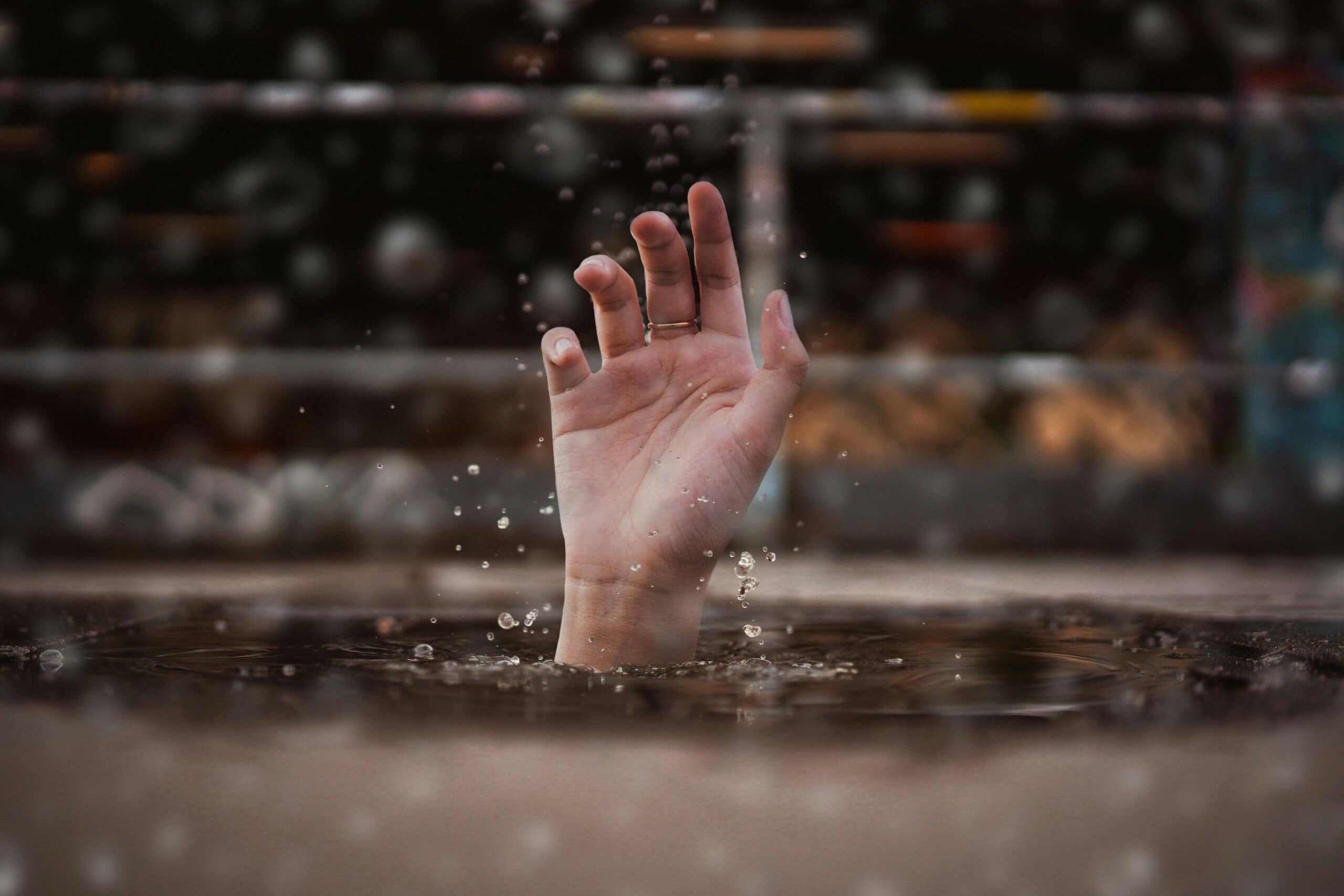 During a drowning accident a hand reaches out of a water body.