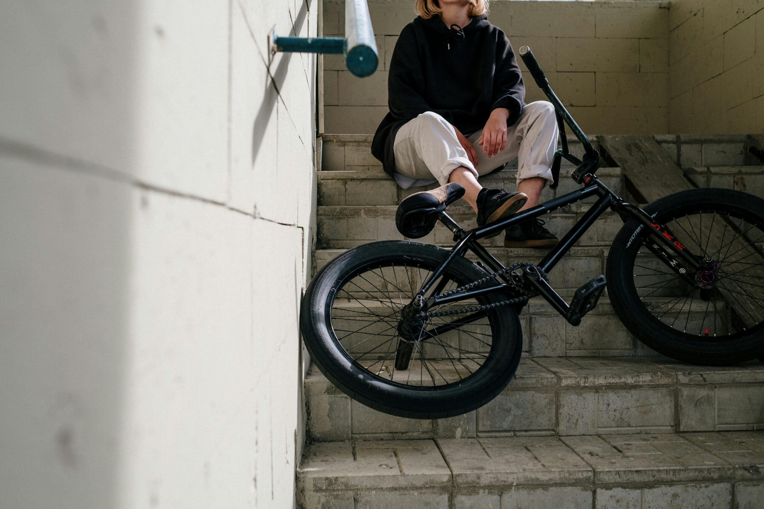 A bike rider sitting on the steps with their bicycle contemplating filing a bicycle accident claim.